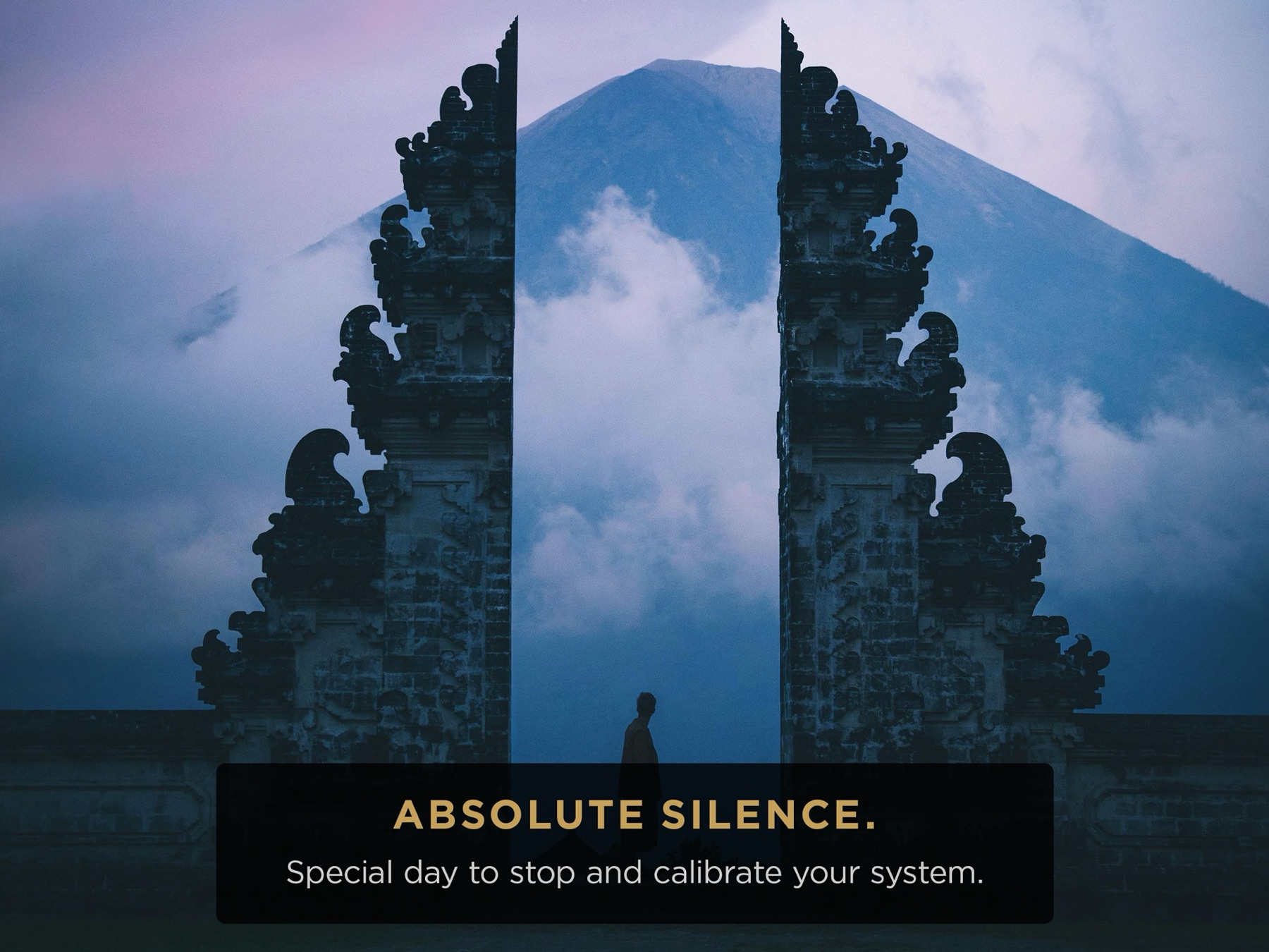 Bulutlu dağın önünde Bali tapınak kapısı; üzerinde "Absolute silence."